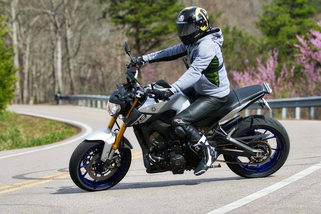 Motorcyklist i skyddsutrustning kör genom en skarp vägkurva